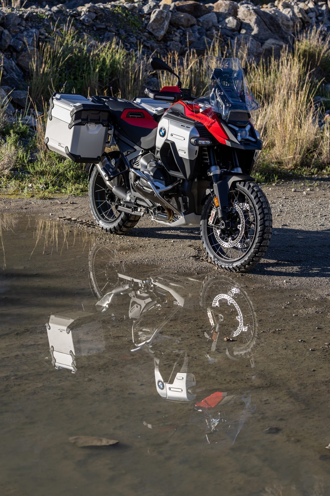 BMW R 1300 GS Adventure con maletas junto a un charco en el campo
