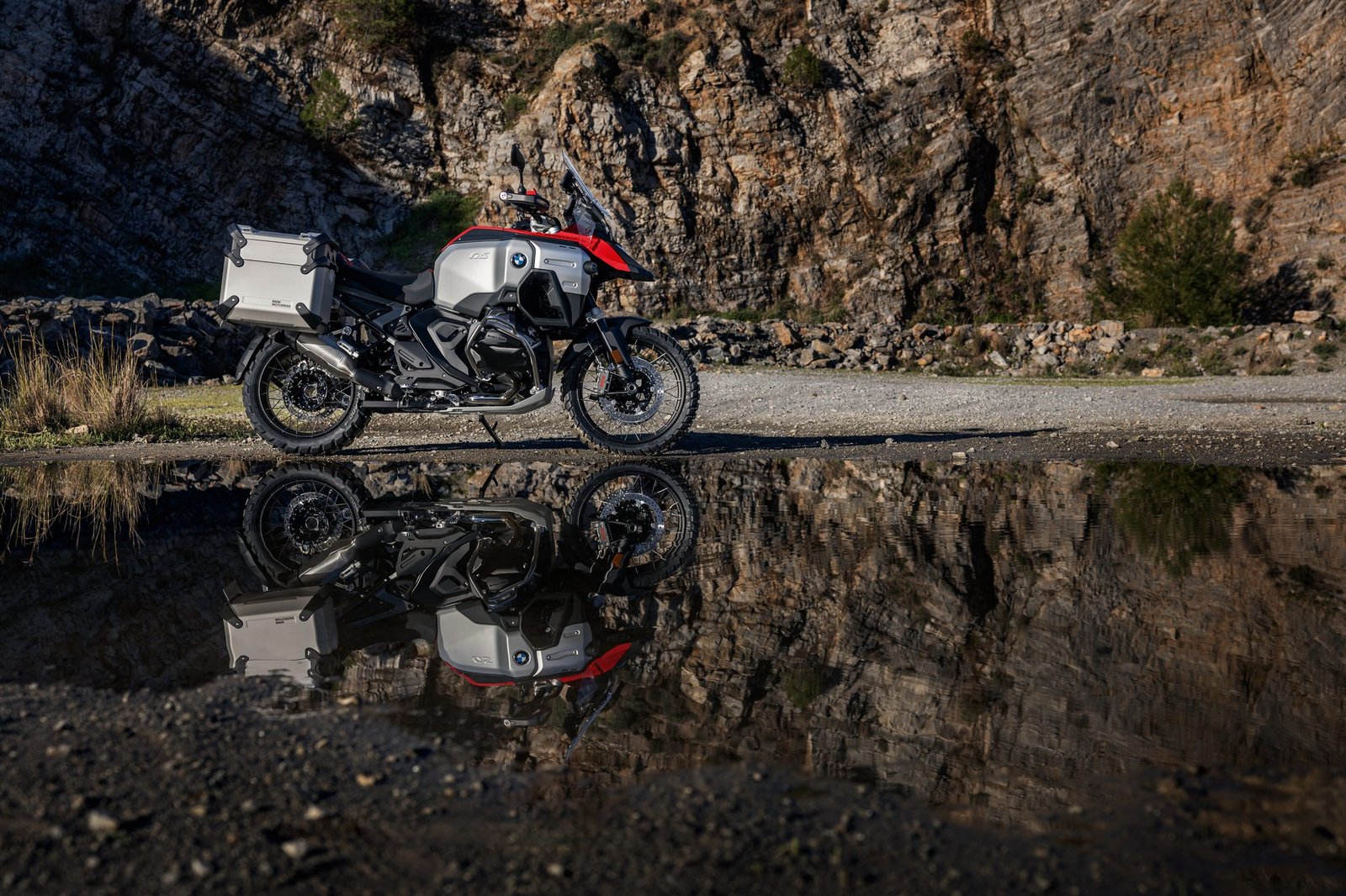 BMW R 1300 GS Adventure reflejada en un charco junto a unas rocas