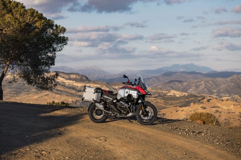 BMW R 1300 GS Adventure 2026: potencia, tecnología y espíritu explorador BMW R 1300 GS Adventure con maletas en un camino de tierra con montañas al fondo