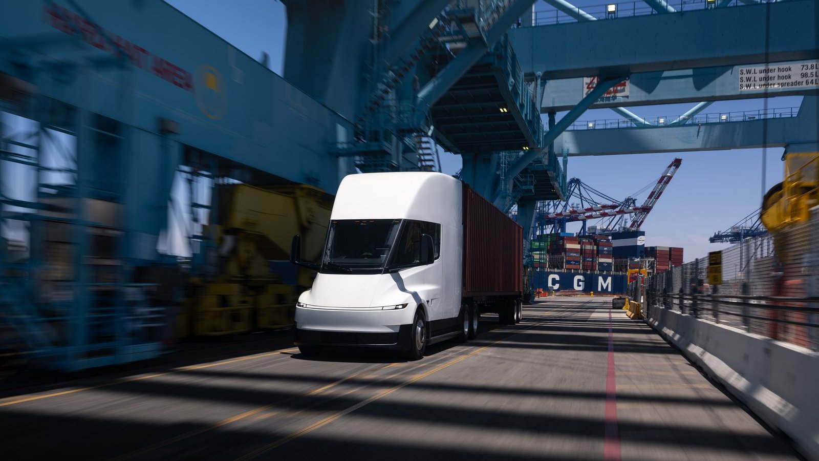 Tesla Semi frente a grúas portuarias en una terminal de contenedores